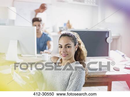 Stock Image - Portrait confident creative young businesswoman working in office. Fotosearch