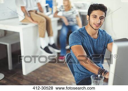 Portrait confident creative young businessman working at computer View Large Photo Image Stock Photo - Portrait confident creative young businessman working at computer. Fotosearch