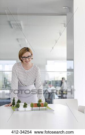 Portrait confident female architect with model in conference room View Large Photo Image Picture - Portrait confident female architect with model in conference room. Fotosearch