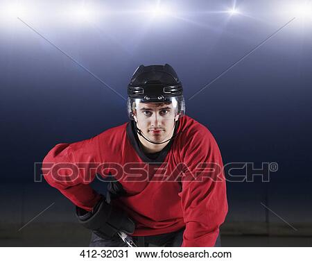 Stock Image - Portrait confident hockey player in red uniform. Fotosearch