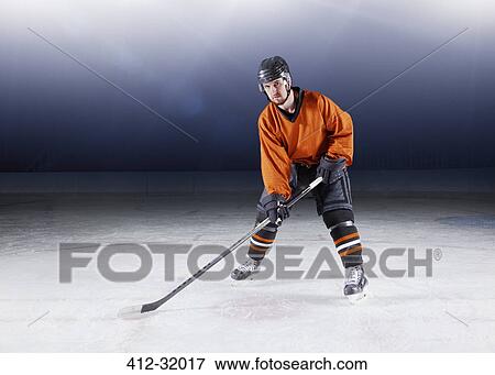 Portrait confident hockey player in orange uniform on ice View Large Photo Image Stock Photo - Portrait confident hockey player in orange uniform on ice. Fotosearch