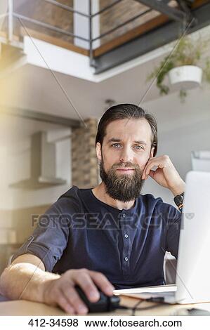 Stock Photo - Portrait confident male design professional working at laptop in office. Fotosearch