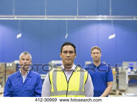Stock Photo - Portrait confident manager and workers in steel factory. Fotosearch