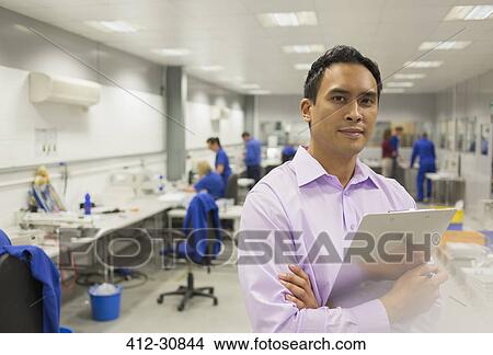 Portrait confident manager with clipboard in steel factory View Large Photo Image Picture - Portrait confident manager with clipboard in steel factory. Fotosearch