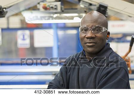 Stock Image - Portrait confident worker in steel factory. Fotosearch