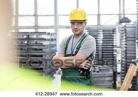 Stock Photo - Portrait confident worker with arms crossed in factory. Fotosearch