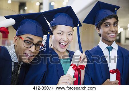 Portrait enthusiastic college graduates in cap and gown holding diplomas View Large Photo Image Stock Photo - Portrait enthusiastic college graduates in cap and gown holding diplomas. Fotosearch