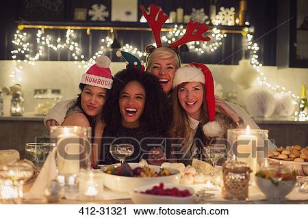 Stock Image - Portrait enthusiastic friends enjoying Christmas dinner. Fotosearch