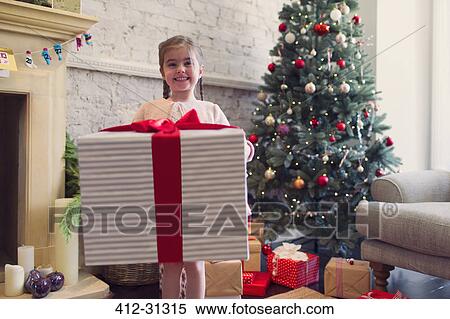 Portrait enthusiastic girl holding large Christmas gift View Large Photo Image Stock Photography - Portrait enthusiastic girl holding large Christmas gift. Fotosearch