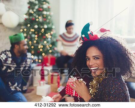 Stock Image - Portrait enthusiastic woman holding Christmas gift. Fotosearch