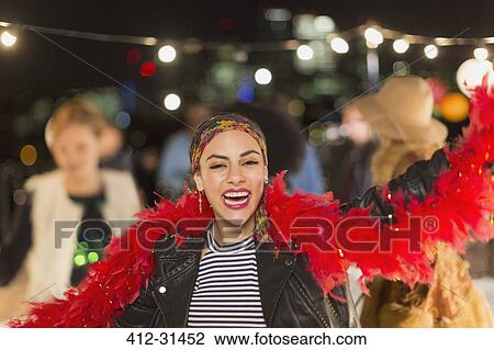 Portrait enthusiastic young woman dancing at rooftop party View Large Photo Image Stock Image - Portrait enthusiastic young woman dancing at rooftop party. Fotosearch