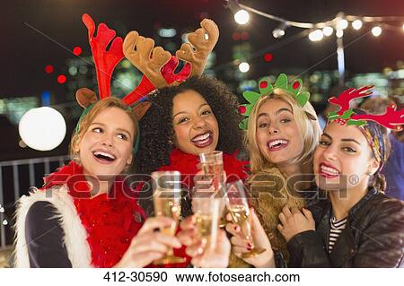 Portrait enthusiastic young women wearing Christmas reindeer antlers and drinking champagne at party View Large Photo Image Stock Image - Portrait enthusiastic young women wearing Christmas reindeer antlers and drinking champagne at party. Fotosearch