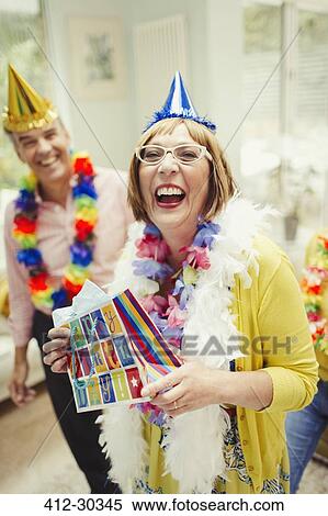Portrait laughing mature woman in party hat holding birthday gift View Large Photo Image Stock Photography - Portrait laughing mature woman in party hat holding birthday gift. Fotosearch
