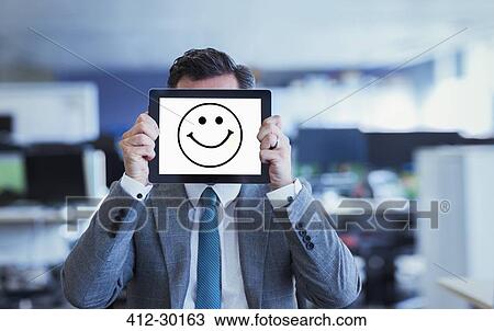 Portrait of businessman covering face with digital tablet in office View Large Photo Image Stock Image - Portrait of businessman covering face with digital tablet in office. Fotosearch