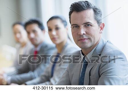 Stock Photography - Portrait of confident businessman and colleagues in a row. Fotosearch