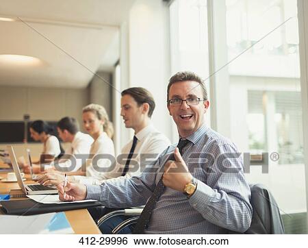 Portrait of confident businessman gesturing thumbs-up in conference room meeting View Large Photo Image Stock Photograph - Portrait of confident businessman gesturing thumbs-up in conference room meeting. Fotosearch