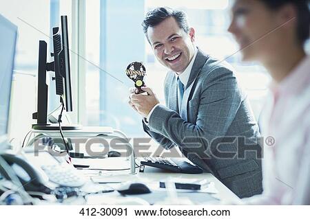 Portrait of enthusiastic businessman holding winner trophy at desk in office View Large Photo Image Stock Image - Portrait of enthusiastic businessman holding winner trophy at desk in office. Fotosearch