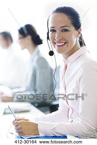 Portrait of smiling businesswoman talking on the phone with headset View Large Photo Image Picture - Portrait of smiling businesswoman talking on the phone with headset. Fotosearch