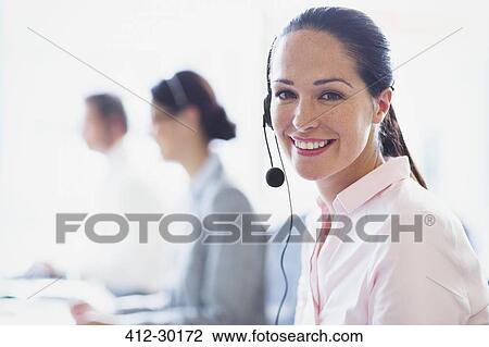 Portrait of smiling businesswoman talking on the phone with headset View Large Photo Image Stock Image - Portrait of smiling businesswoman talking on the phone with headset. Fotosearch