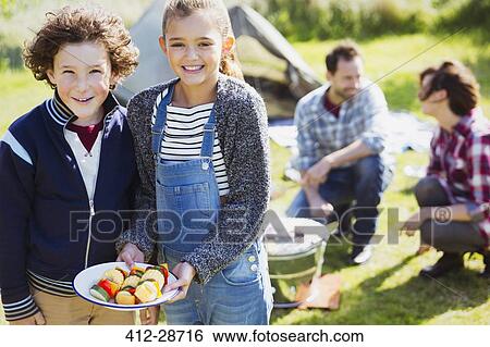 Portrait smiling brother and sister with vegetable skewers at campsite View Large Photo Image Stock Photograph - Portrait smiling brother and sister with vegetable skewers at campsite. Fotosearch