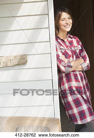 Portrait smiling brunette woman in plaid dress in sunny doorway View Large Photo Image Stock Image - Portrait smiling brunette woman in plaid dress in sunny doorway. Fotosearch