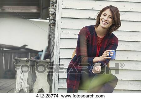 Portrait smiling brunette woman drinking coffee on porch View Large Photo Image Picture - Portrait smiling brunette woman drinking coffee on porch. Fotosearch