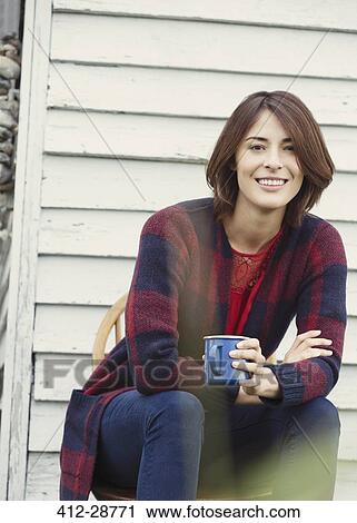Stock Image - Portrait smiling brunette woman drinking coffee outdoors. Fotosearch