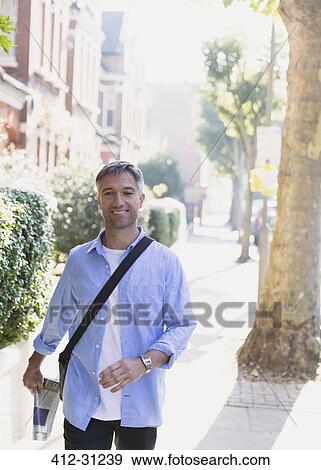 Portrait smiling businessman walking on sidewalk View Large Photo Image Stock Photo - Portrait smiling businessman walking on sidewalk. Fotosearch