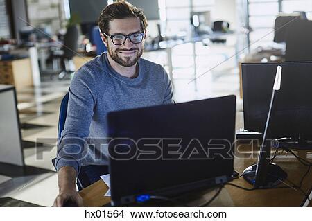 Portrait smiling businessman working at computer in office View Large Photo Image Picture - Portrait smiling businessman working at computer in office. Fotosearch