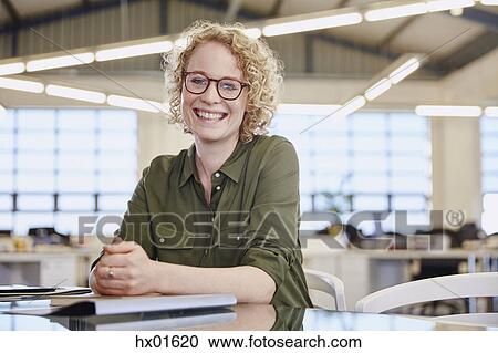 Stock Image - Portrait smiling businesswoman in office. Fotosearch