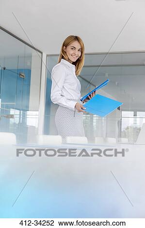 Portrait smiling businesswoman placing folders on conference table View Large Photo Image Stock Image - Portrait smiling businesswoman placing folders on conference table. Fotosearch