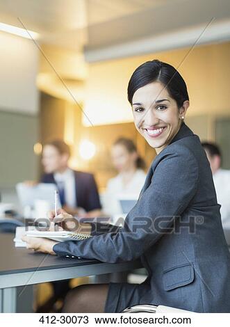 Portrait smiling businesswoman taking notes in conference room meeting View Large Photo Image Stock Image - Portrait smiling businesswoman taking notes in conference room meeting. Fotosearch