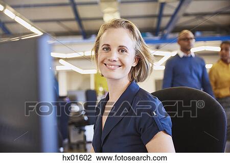 Stock Image - Portrait smiling businesswoman working at computer. Fotosearch