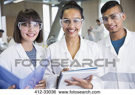 Stock Photograph - Portrait smiling college students in science lab coats. Fotosearch