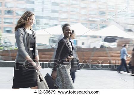 Portrait smiling corporate businesswoman walking outdoors View Large Photo Image Stock Photo - Portrait smiling corporate businesswoman walking outdoors. Fotosearch
