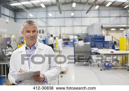 Portrait smiling engineer with clipboard in steel factory View Large Photo Image Stock Photo - Portrait smiling engineer with clipboard in steel factory. Fotosearch