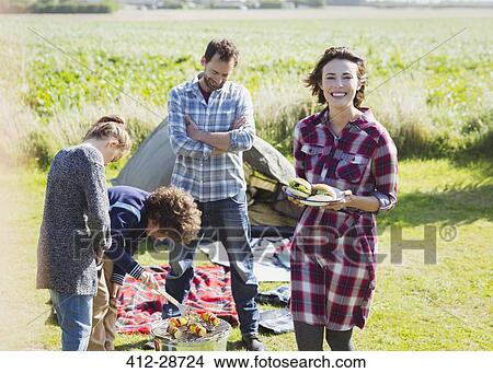 Portrait smiling family barbecuing at sunny campsite View Large Photo Image Picture - Portrait smiling family barbecuing at sunny campsite. Fotosearch