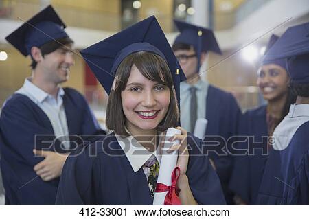 Stock Image - Portrait smiling female college graduate in cap and gown holding diploma. Fotosearch