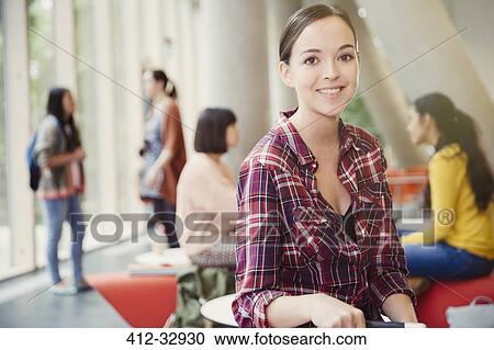 Stock Image - Portrait smiling female college student in commons. Fotosearch