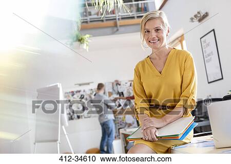 Portrait smiling female design professional leaning on office desk View Large Photo Image Stock Image - Portrait smiling female design professional leaning on office desk. Fotosearch