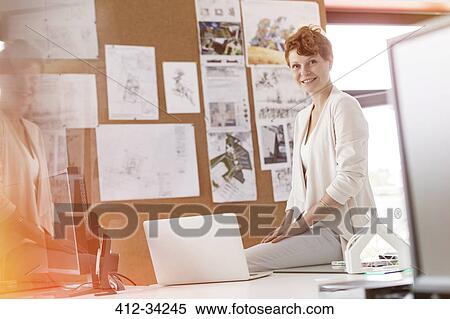 Portrait smiling female designer working at laptop in office View Large Photo Image Stock Photography - Portrait smiling female designer working at laptop in office. Fotosearch