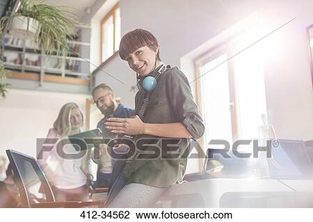 Stock Image - Portrait smiling female photographer design professional with SLR camera in office. Fotosearch