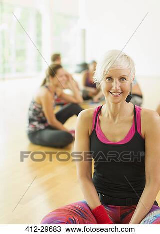 Stock Image - Portrait smiling fitness instructor with headset. Fotosearch