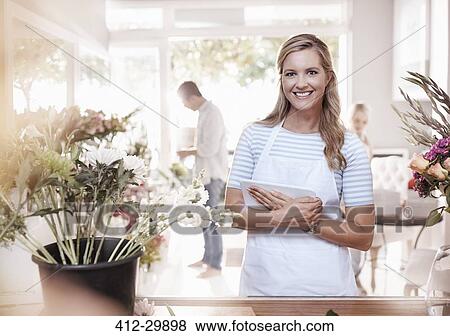 Portrait smiling florist with digital tablet in flower shop View Large Photo Image Stock Photo - Portrait smiling florist with digital tablet in flower shop. Fotosearch