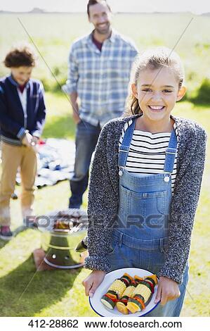 Portrait smiling girl with vegetable skewers at sunny campsite View Large Photo Image Stock Image - Portrait smiling girl with vegetable skewers at sunny campsite. Fotosearch