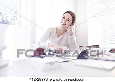 Stock Image - Portrait smiling interior designer with swatches in office. Fotosearch