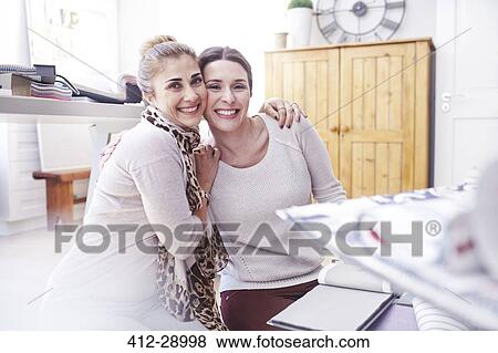 Portrait smiling interior designers hugging in office View Large Photo Image Stock Photo - Portrait smiling interior designers hugging in office. Fotosearch