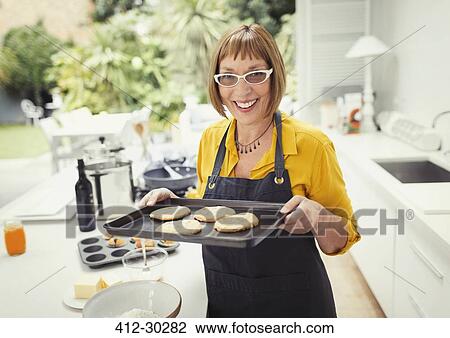 Portrait smiling mature woman baking cookies in kitchen View Large Photo Image Stock Image - Portrait smiling mature woman baking cookies in kitchen. Fotosearch