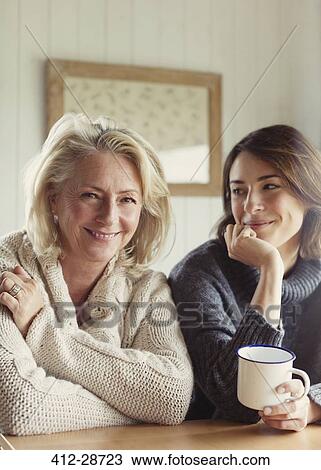 Stock Image - Portrait smiling mother and daughter in sweaters drinking coffee. Fotosearch