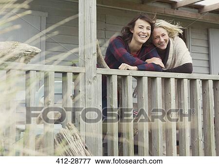 Stock Photo - Portrait smiling mother and daughter on porch. Fotosearch
